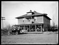 Hotel Grandview, at Grandview, WA. Guests sitting on porch. Auto parked in front of hotel.