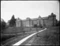 Buildings of St. Vincent's Hospital, Portland, on hill. Wood walkway leading up hillside in foreground.