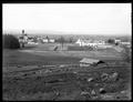 Distant view of State Mental Hospital, Salem. Open field with power pole in foreground.