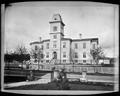 Central School, Portland, on present site of Portland Hotel. Open gate looking to 6th Ave and Morrison (?) in foreground. Trees along street.