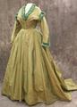 Dress of grey-green silk faille with V-neckline trimmed in teal fringed and pleated satin ribbon