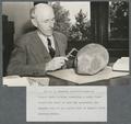 E. L. Packard examining a fossilized prehistoric turtle skull
