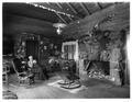 Interior of Cloud Cap Inn. Sarah Langille seated in one of several chairs. Stone fireplace at right.  Positive image.