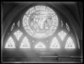 Round stained glass window in First Congregational Church, Portland. Pews in foreground.