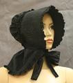Sunbonnet of black cotton with stiffened, quilted brim trimmed in ruffled self-fabric
