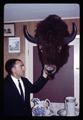 Unidentified Iranian visitor posing with mounted bison head, circa 1965