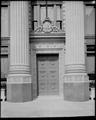 Detail of entryway, US National Bank, Portland. Iron door flanked by stone columns.