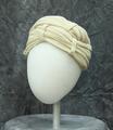 Turban of off-white jersey knit with lots of gathering and folding to create texture and design