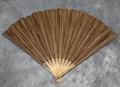 Folding fan of wood sticks mounted with brown stained paper