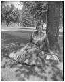 Promotional photo of an OSC co-ed posing in the shade of a tree