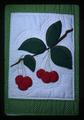 Closeup of cherry square on Women for Agriculture quilt, 1979