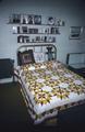 Christmas Star pattern quilt, showing head of bed with pillows and doll, made by Mrs. Shirley Drummond