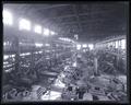 Interior of Factory. Floor is covered with parts, machinery and other odds and ends.