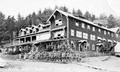 Soldiers posed on porch and steps of large wooden inn