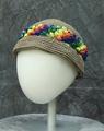 Hat of muted brown crochet with textured band of rainbow crochet in a raised stitch of baubles