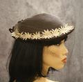 Hat of brown straw (or horsehair) with a band of off-white daisy appliques accented with rhinestones