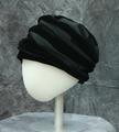 Toque-style hat of alternating bands of black satin and black velvet with flat crown of black velvet