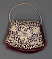 Purse of ribbed maroon velvet embellished with delicate silver coils in a radiating sun