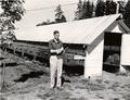 Man standing by mink cages