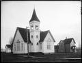 Methodist Episcopal Church, Yamhill, OR. Board sidewalk across dirt street in foreground, house in background.