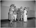 Students in Hawaiian dress posing with ukuleles at an international student reception