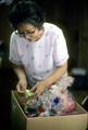 Mrs. Yamano with strands of cranes in box. Part of a senbarzuru, or thousand cranes threaded on strands, made to wish someone special good luck.