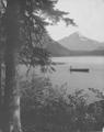 Mt. Hood in background, lake with boater in foreground.