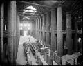 Interior view of Forestry Building on Lewis & Clark Exposition site, from balcony overlooking display cases on ground floor.