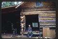 Tommy Schneider and the log cabin he built