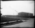 Full view of Benson Polytechnic School, Portland. Main building in front, shop buildings in background, with power plant between. Field and street in foreground.