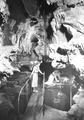 Two women exploring the caves with one leaning over railing