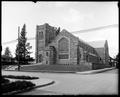 Westminster Presbyterian Church, Portland. Stone building with stained glass windows in front. Schuyler St. in foreground, houses in background.