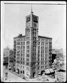 Full view, Northwestern National Bank, 6th and Morrison, Portland. Building under construction, debris around unfinished street level stores.