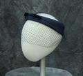 Hat of a navy blue woven silk gauze ring is turned up at front with velour ribbon bow at front