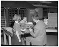 Faculty member showing children computer, Winter 1959