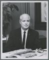 James H. Jensen seated at desk, circa 1965