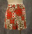 Skirted shorts of olive, scarlet and white cotton canvas in a dynamic windowpane print with circles and flowers