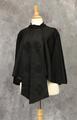 Cape of black silk satin with box pleated round collar that is stitched in the center