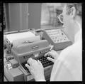 An unidentified faculty member working with a teletypewriter