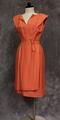 Dress of peach colored raw silk knit with scoop neckline with slit at center-front