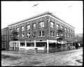 Athens Hotel building, Portland, with grocery on corner. Streetcar tracks in foreground street.