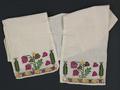 Sash of woven linen with colorful cross stitch embroidery at each end