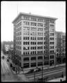 Corbett Building, Portland, at corner of Morrison and 5th. Security Savings on corner, autos parked along street.