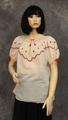 Blouse of ivory cotton gauze with red embroidered yoke in star motif, zig-zag stitch and geometric zig-zag pattern