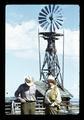 Dean Frischknecht and Reub Long by windmill at Harrison Ranch, near Fort Rock, Oregon, circa 1972