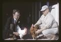 Dr. Paul Bernier (left) and two roosters from cross of a red and a white rooster, 1964