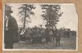 Group of men visiting, smoking cigars, small boy, woman standing by a carImage entitled ""Friend Picnic, 1918""