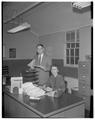 Journalism professor Sam Bailey and secretary Pat Eccles folding weeklies, January 1955