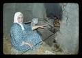 Person baking bread in stone oven, Middle East, November 1979