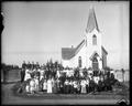 Church building at Warren, OR. Congregation lined up in front of church.